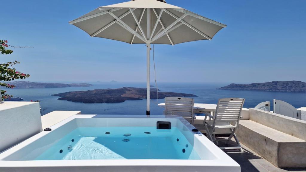 a hot tub with an umbrella and a table and chairs at Karpimo Horizon - Caldera Sunset View - Private Hot Tub - Firostefani in Firostefani