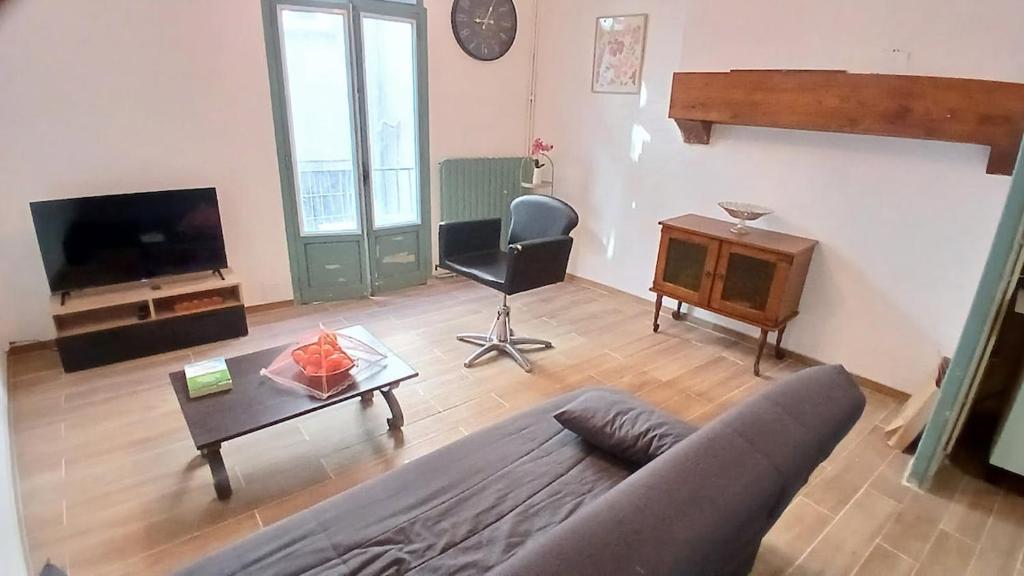a living room with a couch and a table at Maison T3 - Hypercentre historique - WIFI in Villefranche-de-Rouergue