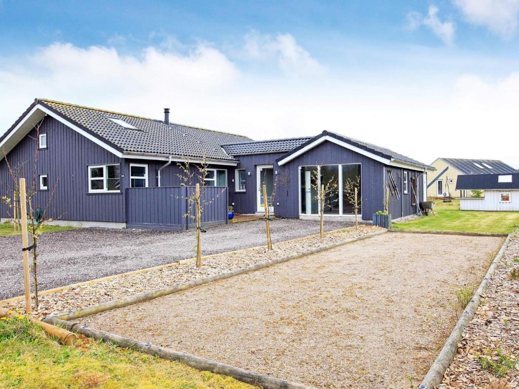 a blue house with a driveway in front of it at 10 person holiday home in Brovst-By Traum in Brovst