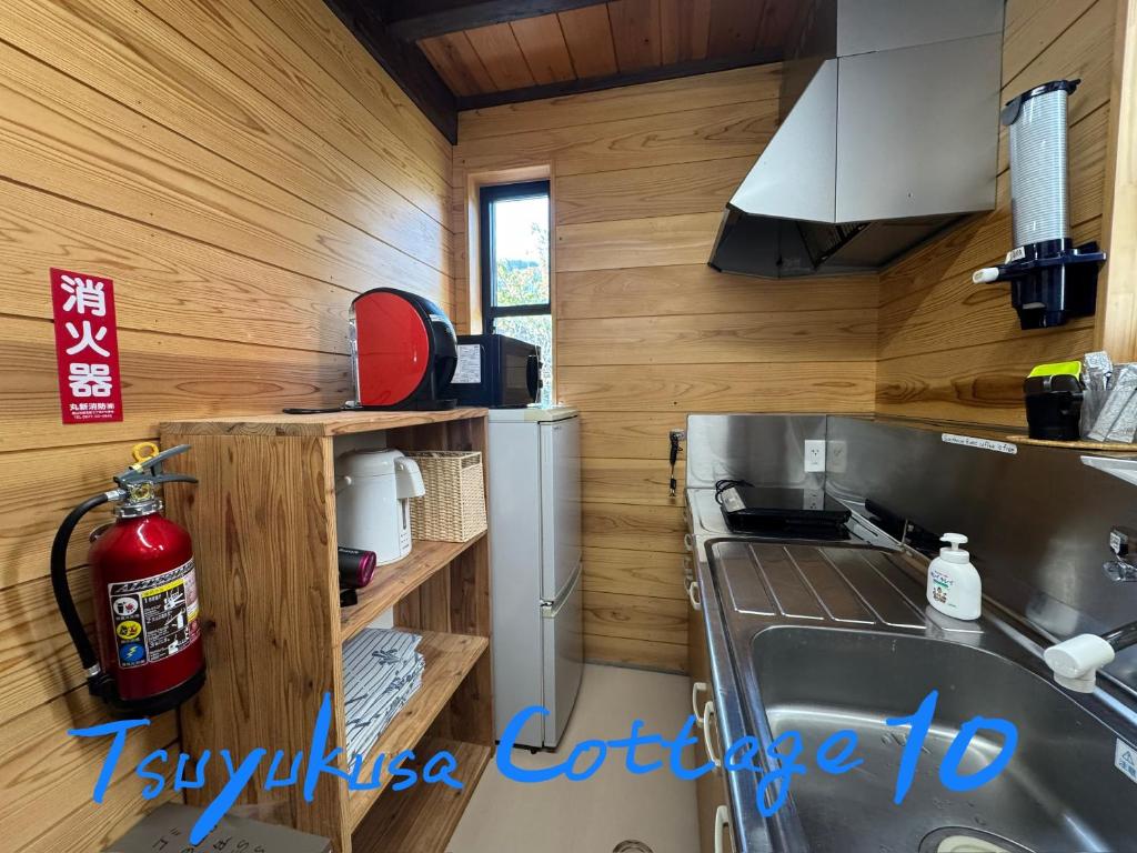 une cuisine avec un évier et un réfrigérateur dans l'établissement Tsuyukusa, à Takayama