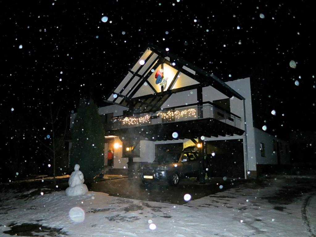 a building with a truck parked outside in the snow at Gruppenfreundliche Villa in Liesen in Hallenberg