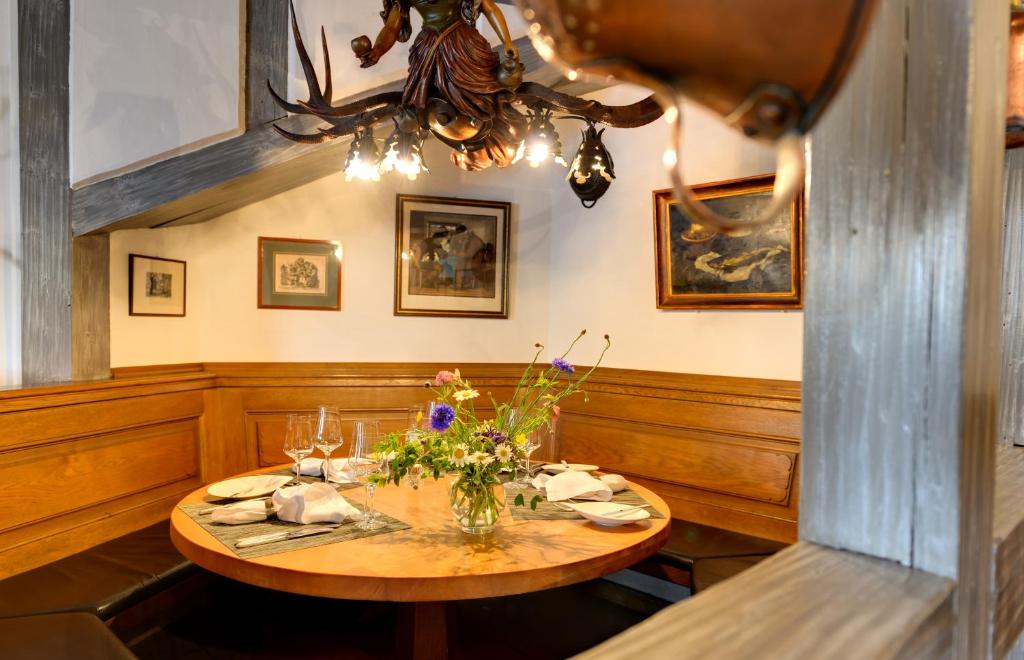 a dining room with a table with flowers on it at Romantik Hotel Gasthaus Rottner in Nuremberg