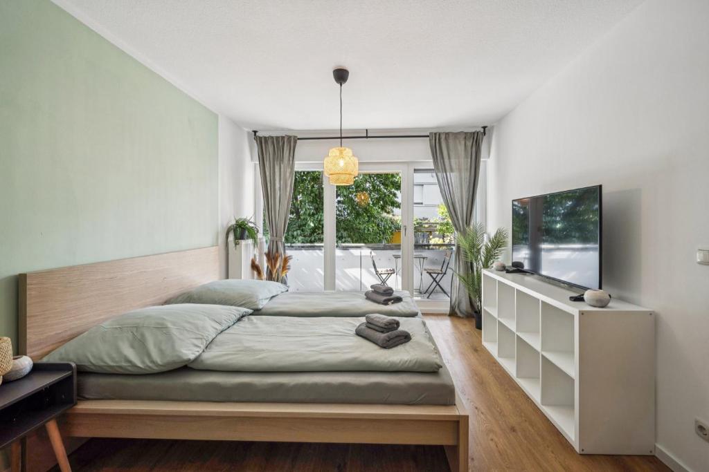 ein Schlafzimmer mit einem großen Bett und einem Fernseher in der Unterkunft Royal Garden Residence in Dresden