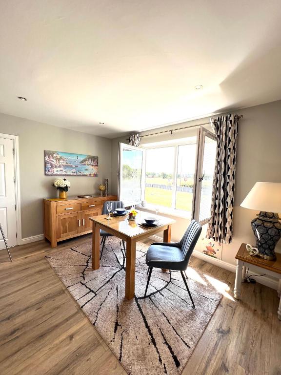 a dining room with a table and chairs and a window at Poppy Annex in Wellow