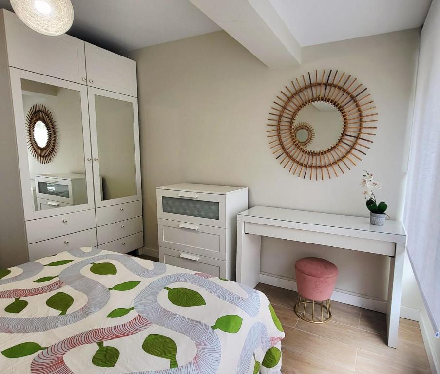 a bedroom with a bed and a desk and mirror at Parque Playa II in Gijón