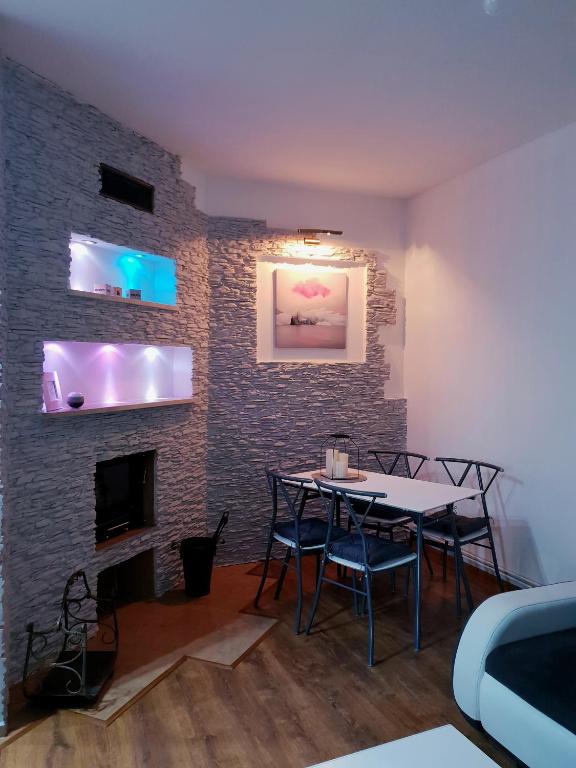 a dining room with a table and a brick wall at Apartamenty Biały Kamień in Wałbrzych