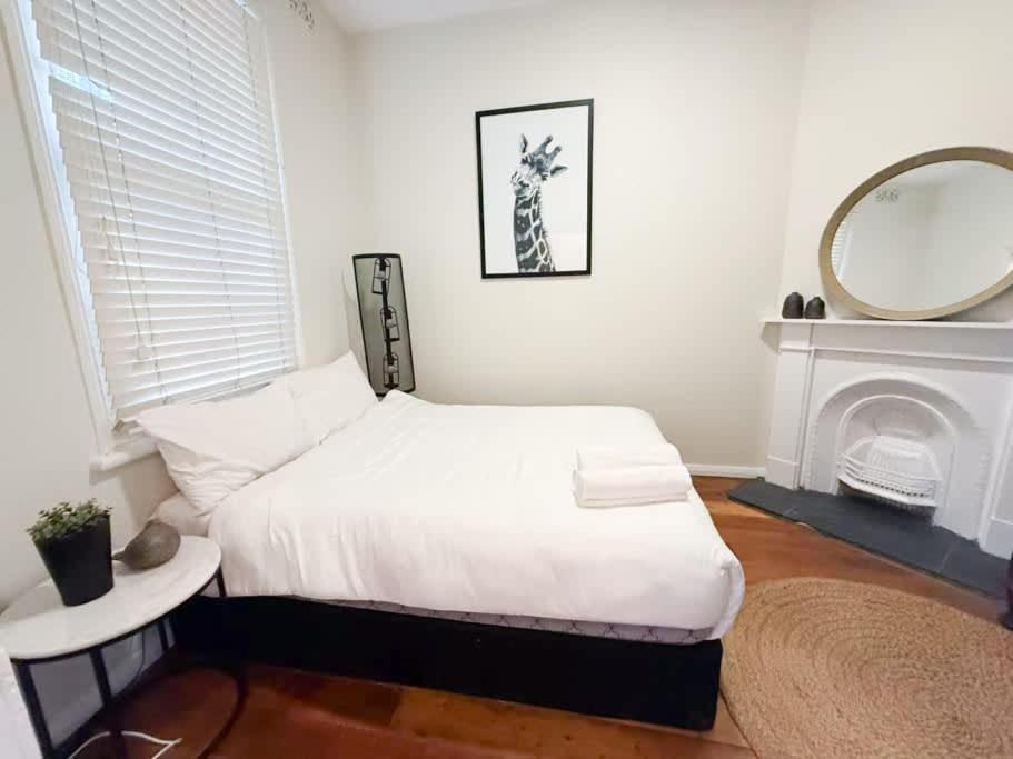 a bedroom with a bed with a mirror and a fireplace at Sydney Dawes point 4bed cls Sydney Harbour bridge in Sydney