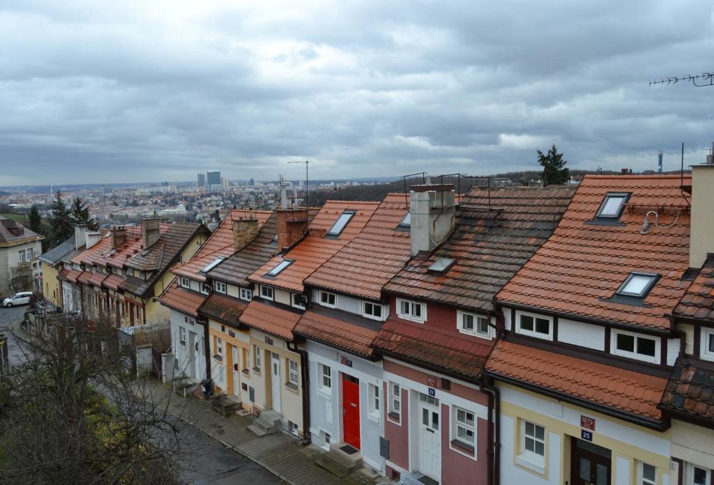 una fila de casas con techos rojos en una ciudad en Pravouhla, en Praga