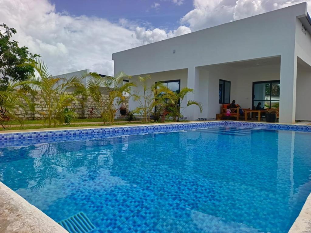 Una gran piscina azul frente a una casa en Diani Dream luxury apartment, en Diani Beach