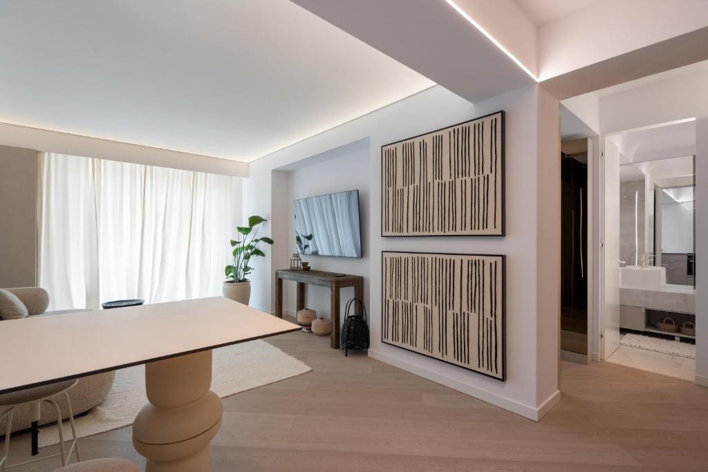 a white living room with a table and a mirror at Cortina Luxe Lodge in Voluntari