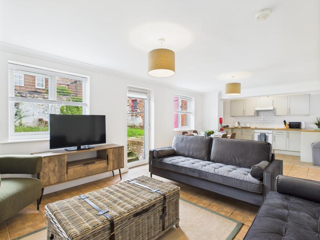 een woonkamer met een bank en een tv bij Spacious Apartment with Private Garden in Norwich