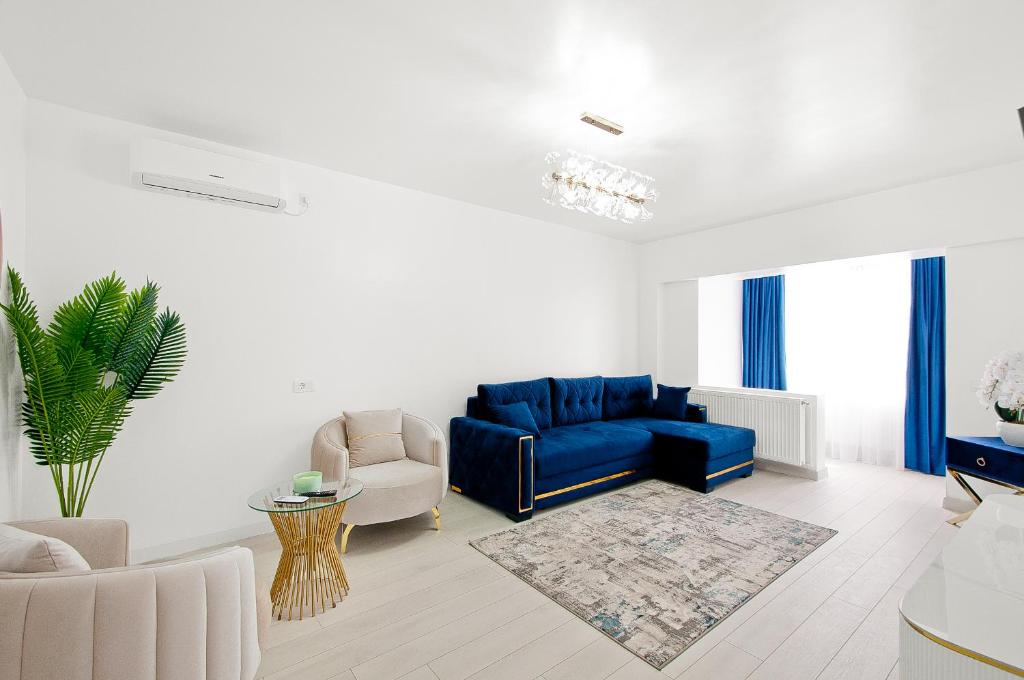 a living room with a blue couch and a chair at Central Aparthotel in Galaţi