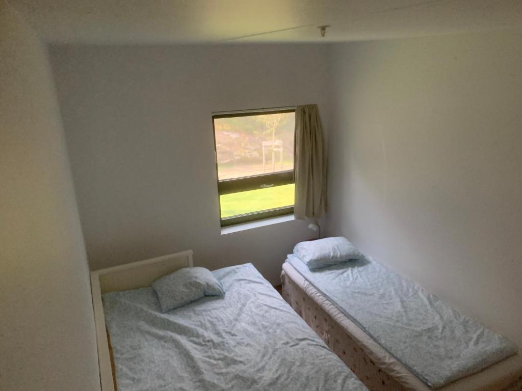two twin beds in a room with a window at Peer Gynts vei 77 in Moss