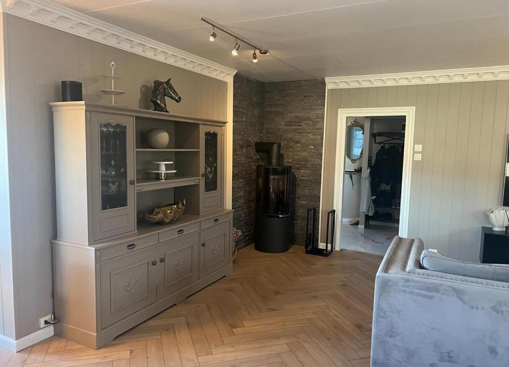 un soggiorno con un grande mobile grigio in una stanza di Villa Hana a Sandnes