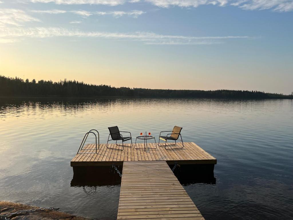 due sedie e un tavolo su un molo su un lago di Villa Laura a Savonlinna