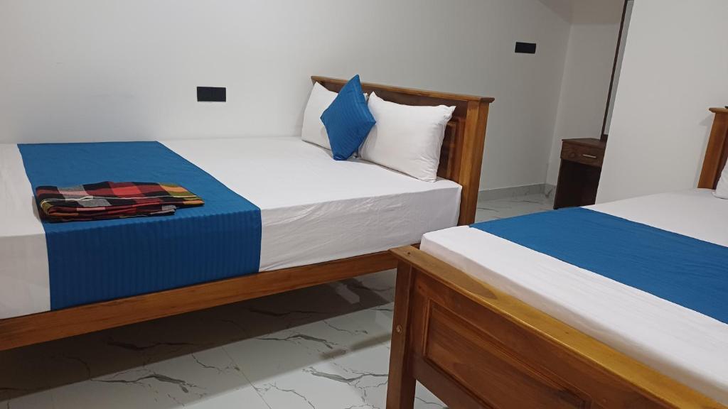 two twin beds in a room withthritisthritisthritisthritisthritisthritisthritisthritisthritis at Selva Guest House in Trincomalee