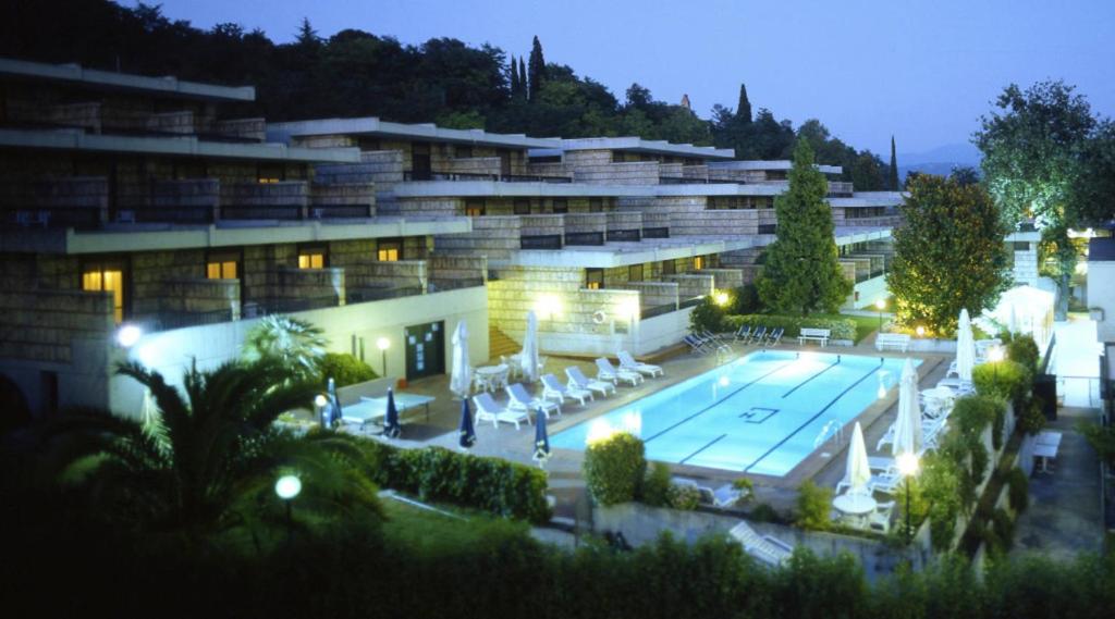 a large building with a swimming pool in front of it at Hotel Garden Terni in Terni