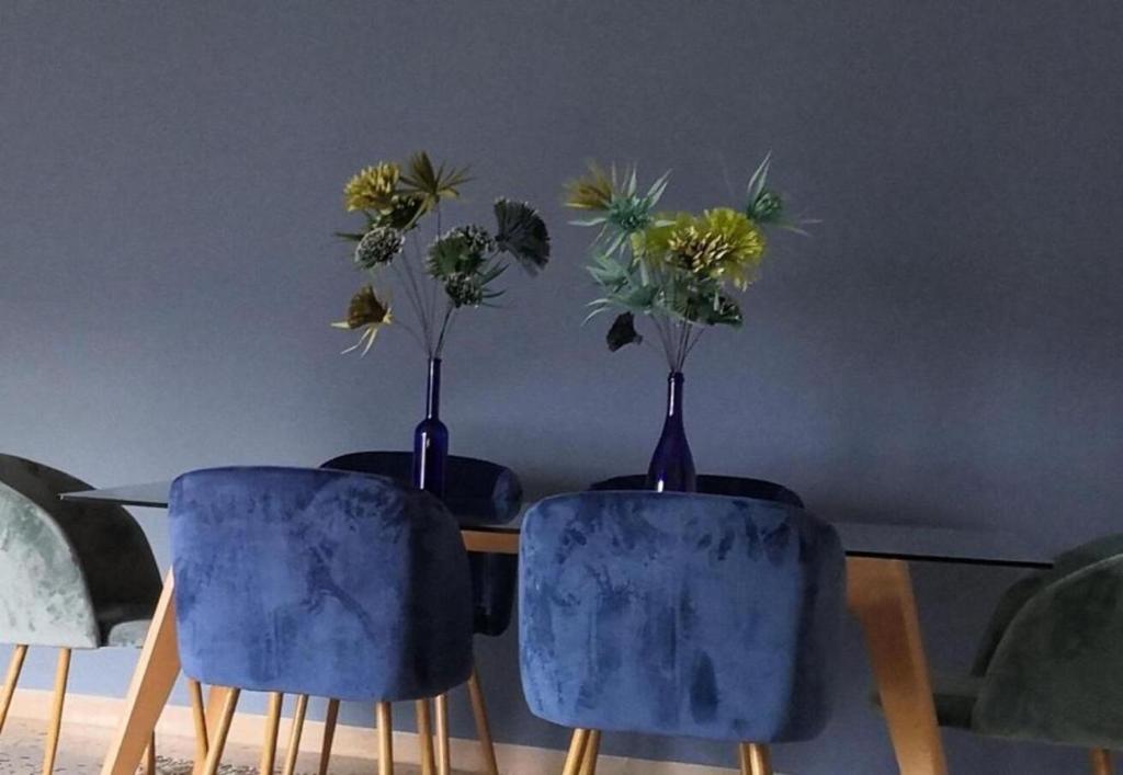 two blue vases with flowers in them sitting on a table at Zibibbo Apartment in Pantelleria