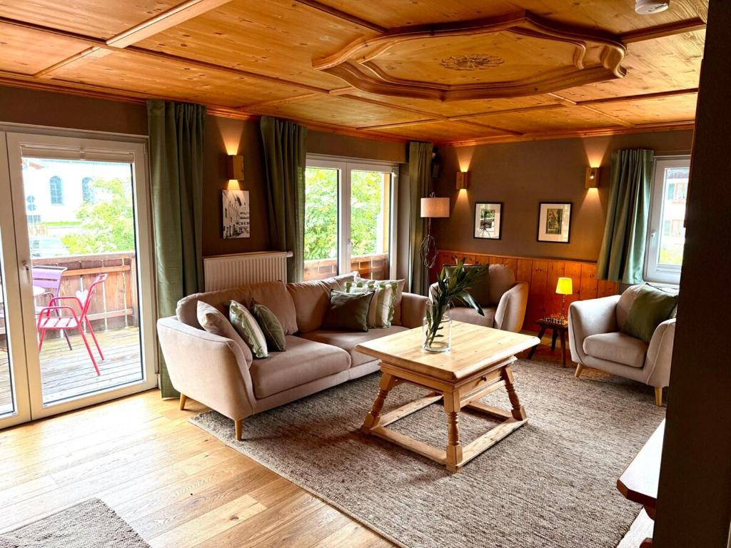 普夫龙滕FeWo Pfronten - Berge und Bilder OG的客厅里有一张沙发和一张桌子。