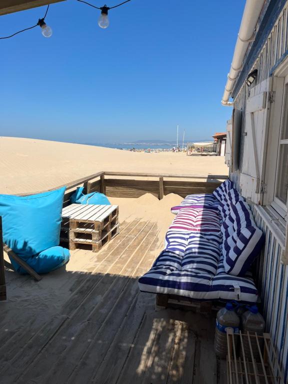 a deck with beds and pillows on the beach at Lisbon Beach Hut - Costa Caparica in Costa da Caparica