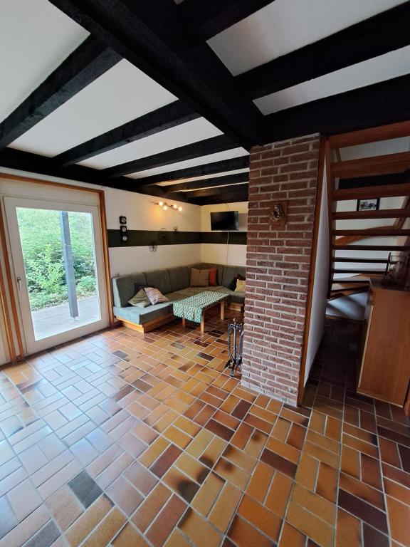 a living room with a couch and a brick wall at Landhaus in Bad Berleburg