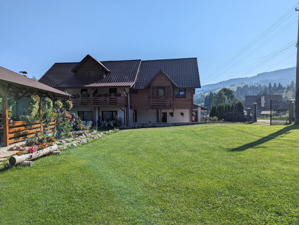 a house with a large yard in front of a house at Pensiunea Casa Pancu in Ceahlău