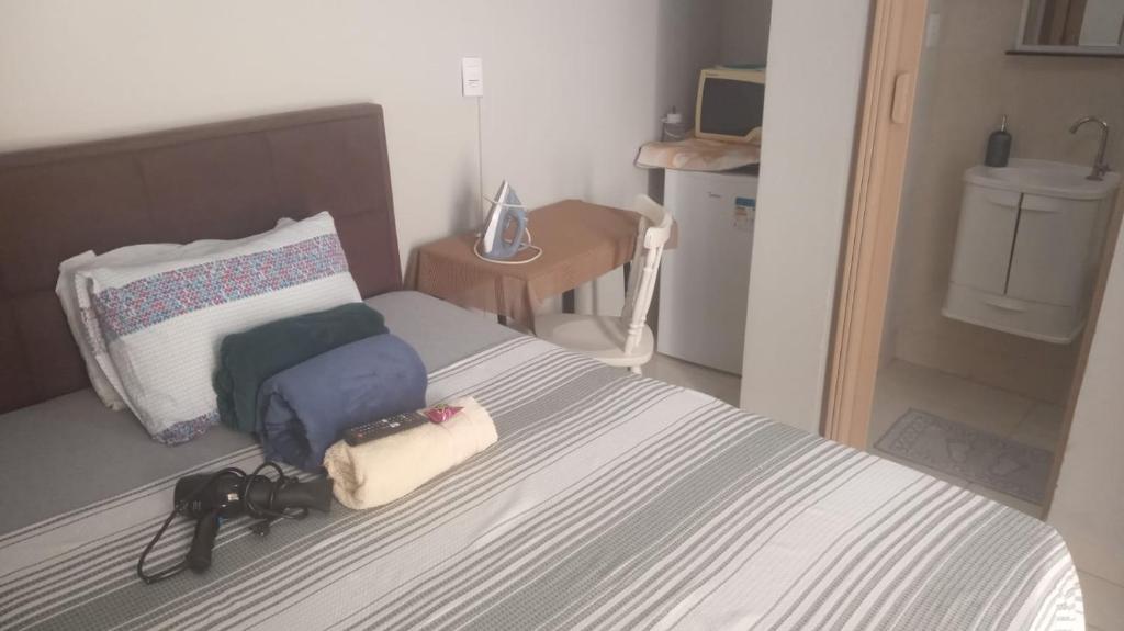 a bedroom with a bed with two bags on it at Suite para seu descanço in Indaiatuba