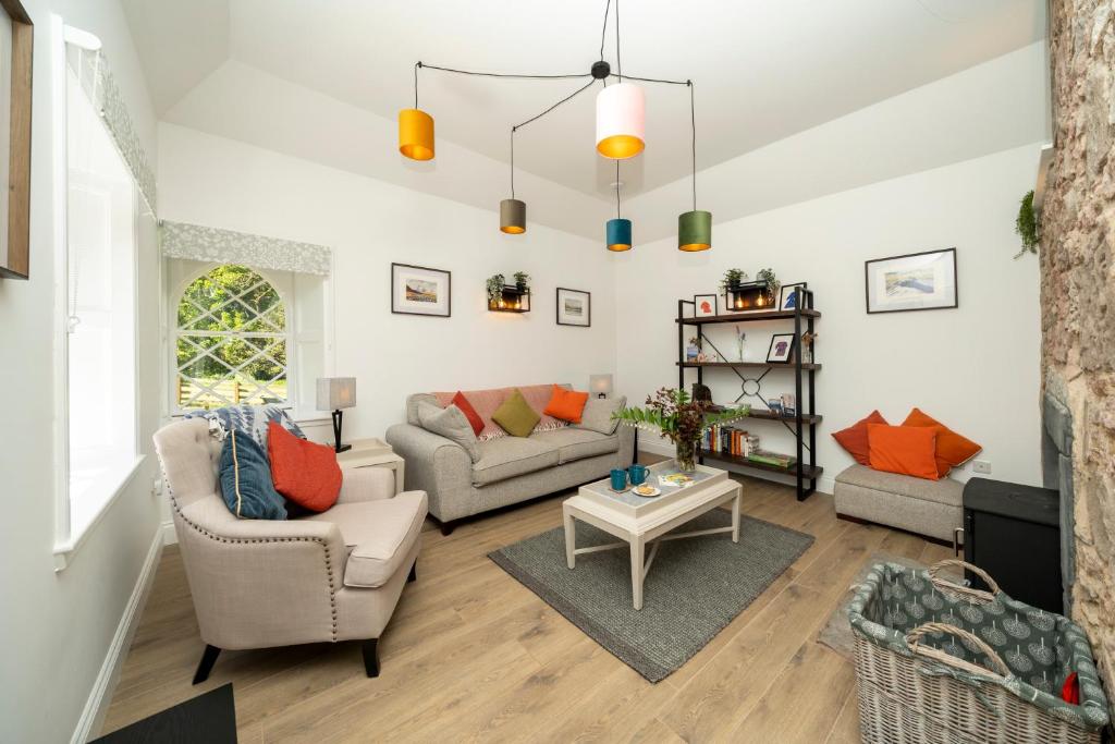 a living room with two couches and a table at Newtonmill - Tranquillity in Rural Angus in Edzell