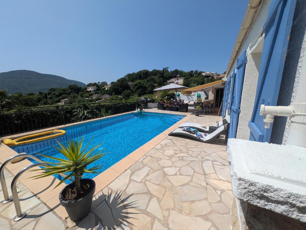a swimming pool with a potted plant next to a building at Beautiful Provencal villa in Les Adrets de l'Esterel