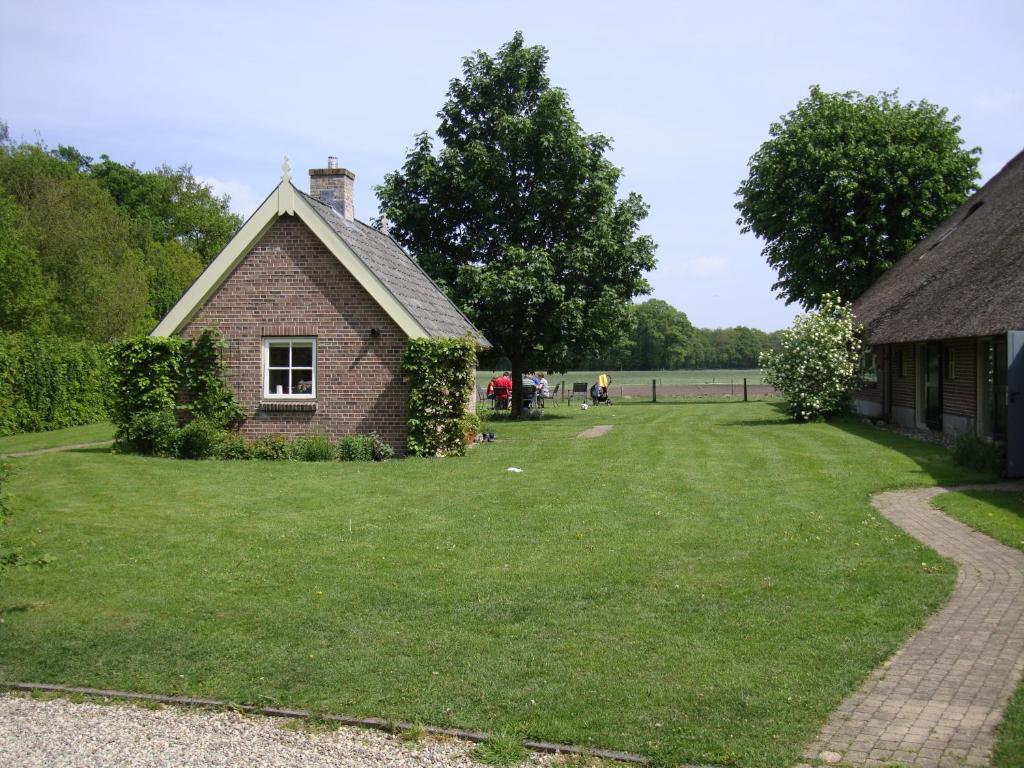 una vieja casa de ladrillo con un patio de hierba en Erve Ziegers, en Vilsteren