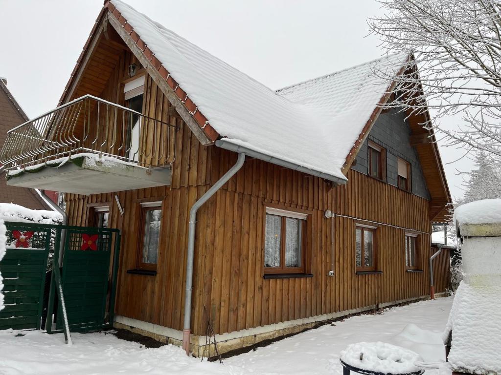 une maison en bois avec un toit couvert de neige dans l'établissement Ferienhaus in Elend, à Elend