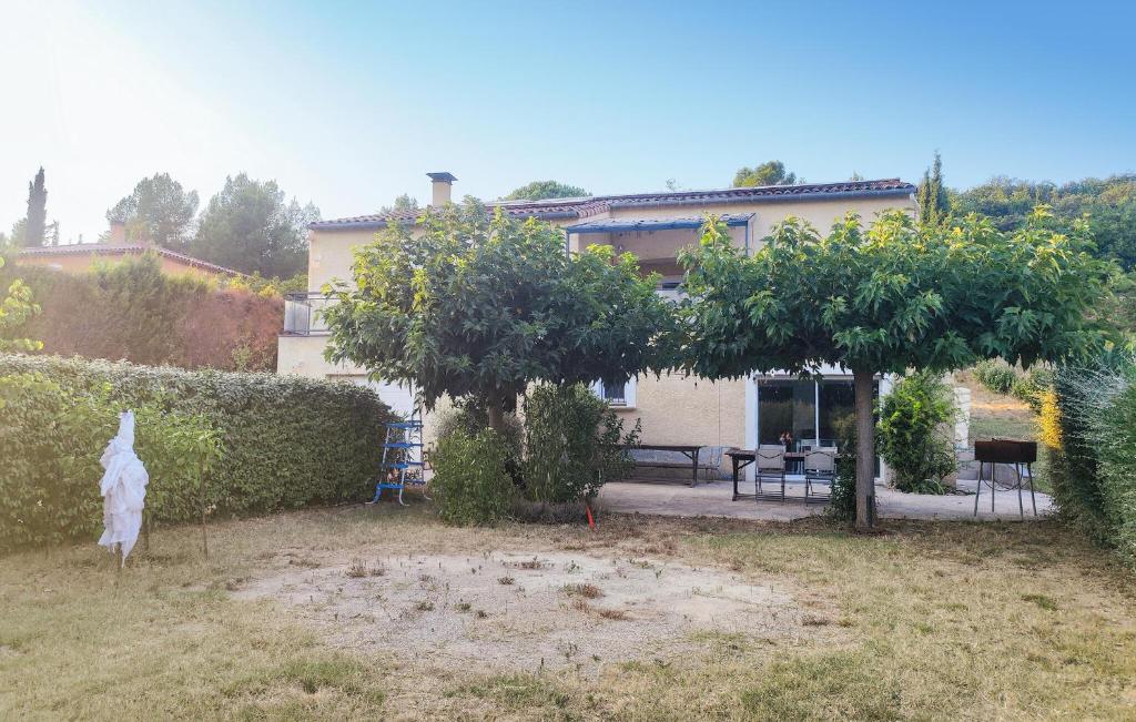 un jardin avec deux arbres et une maison dans l'établissement Appt Avec Jardin Prive, à Lieuran-Cabrières