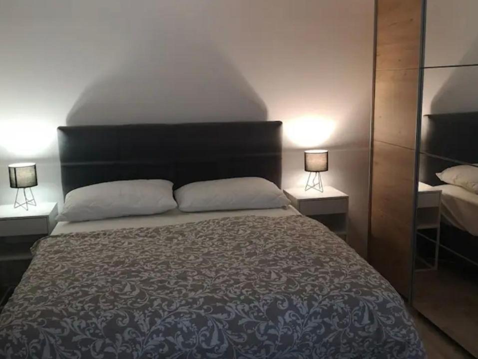 a bedroom with a large bed with two lamps at Wiew in Selca