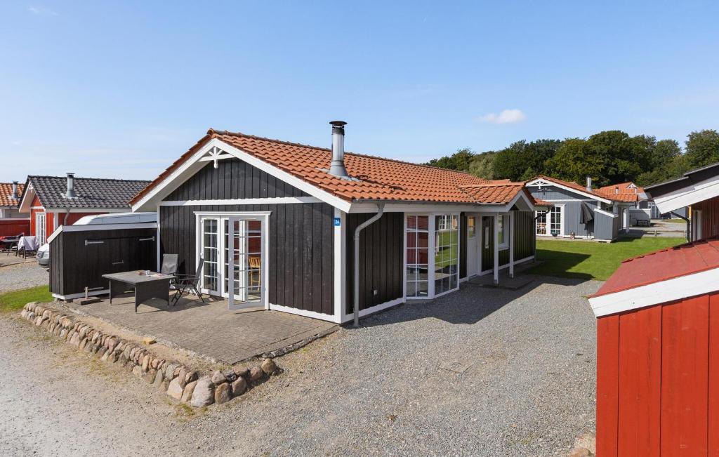una piccola casa nera con un tavolo da picnic nel vialetto di Stunning Home In Gråsten With Sauna a Gråsten
