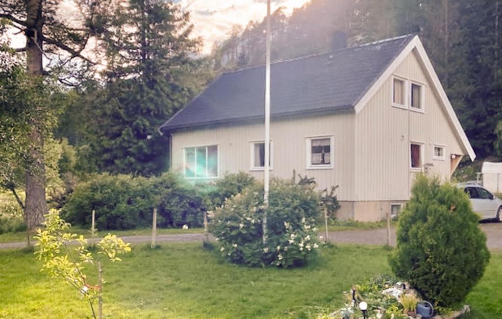 een wit huis met een zwart dak in een tuin bij 5 Bedroom Nice Home In Namsos in Namsos