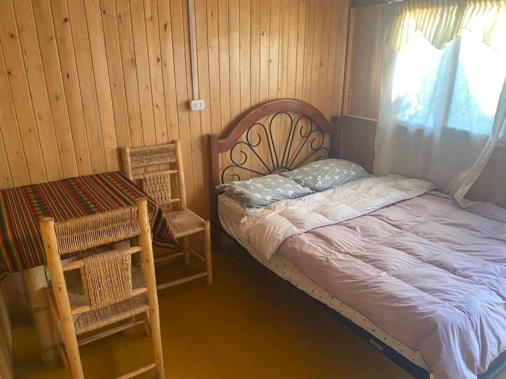 a bedroom with a bed and a chair and a window at Coco y Ainhoa Lodge in Paracas