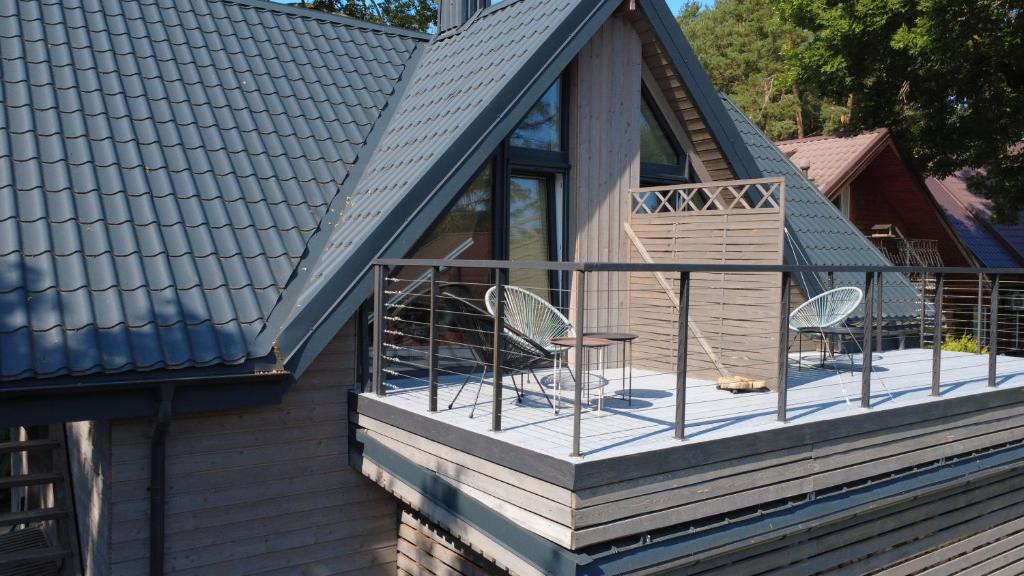 a deck with two chairs and a table on a house at Rytas cozy apartment in the guest house with the terrace and the stunning view to the river side in Birštonas