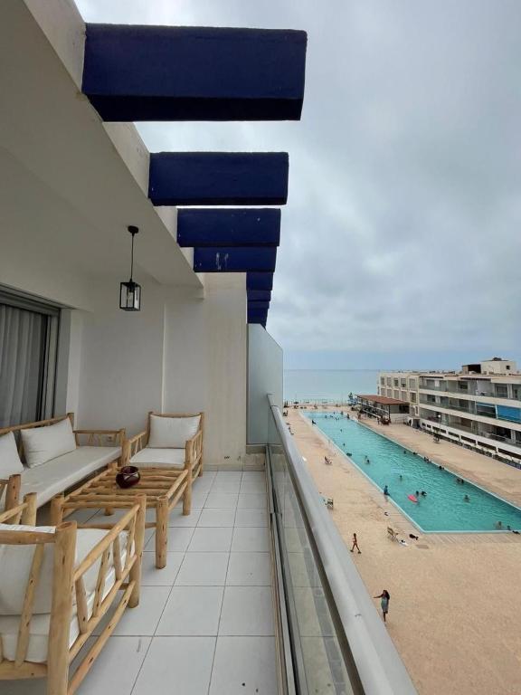 a balcony with a swimming pool and a beach at Beach & Pool - Adan Beach in Aourir