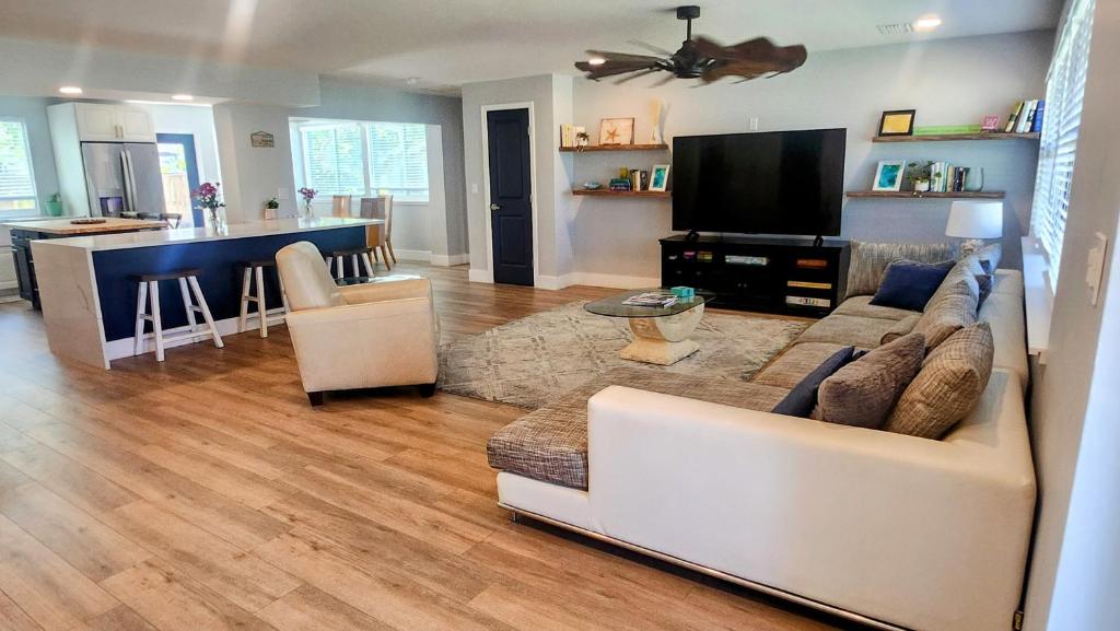 フォートマイヤーズビーチにある1 Block To Beach - Fully Upgraded Spacious & Quietの白いソファとキッチンのあるリビングルーム