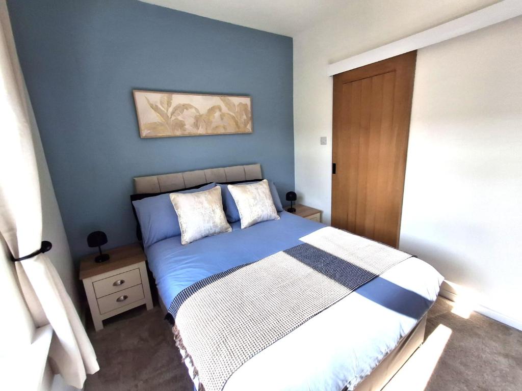 a bedroom with a bed with a blue wall at Alfreton Town Contractor Stay in Alfreton