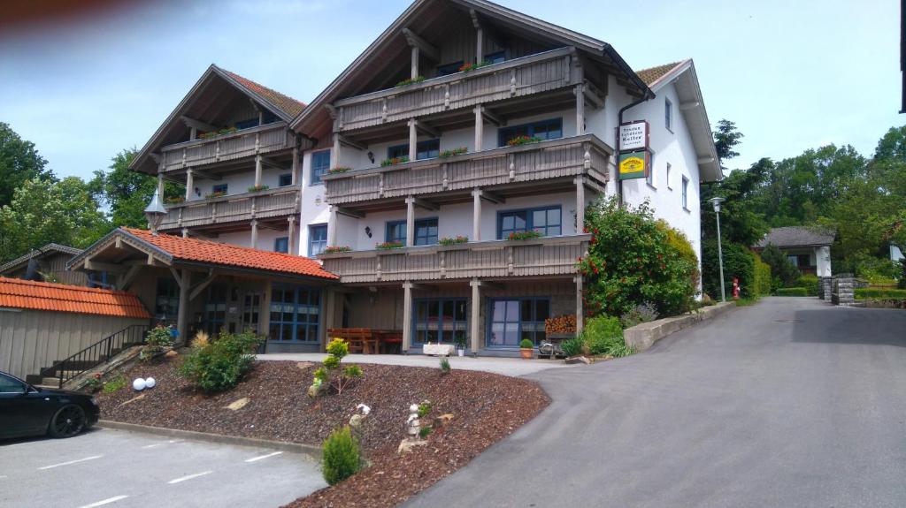 a large building with a parking lot in front of it at Pension Landhaus Koller - Adults only in Bodenmais