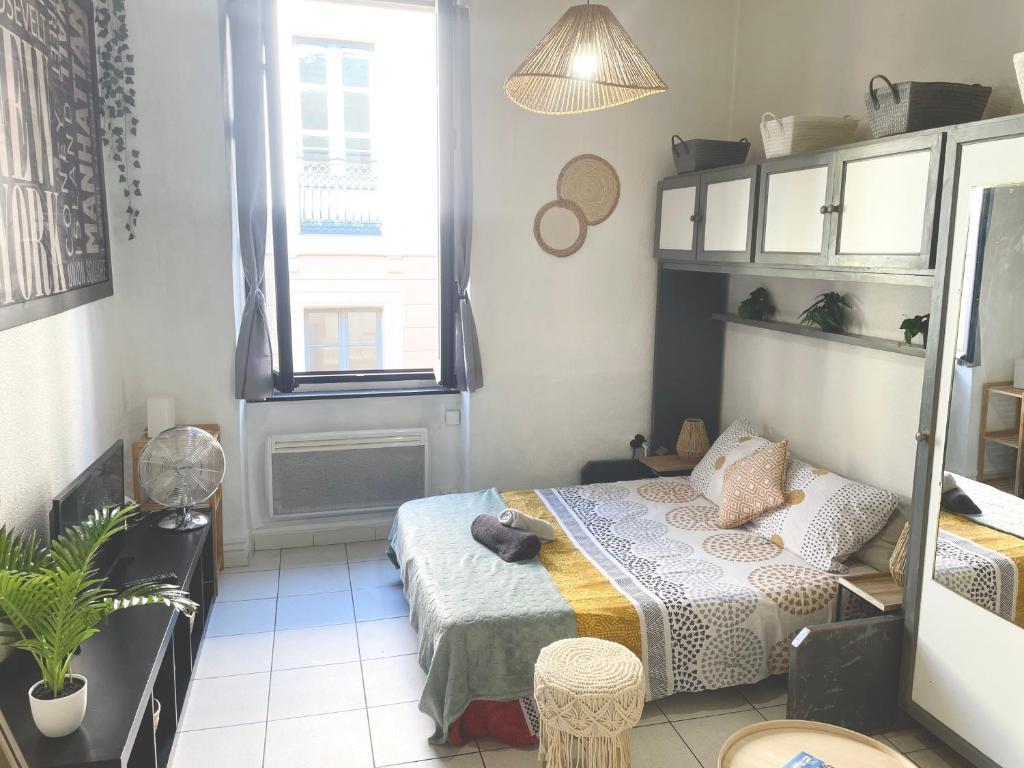 a small bedroom with a bed and a window at Les Studios de la Bastide in Carcassonne