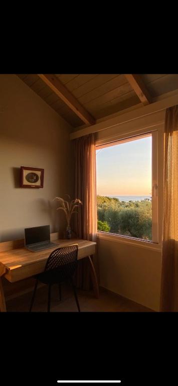 a desk with a laptop on it next to a window at Fiskouri Anthem in Preveza