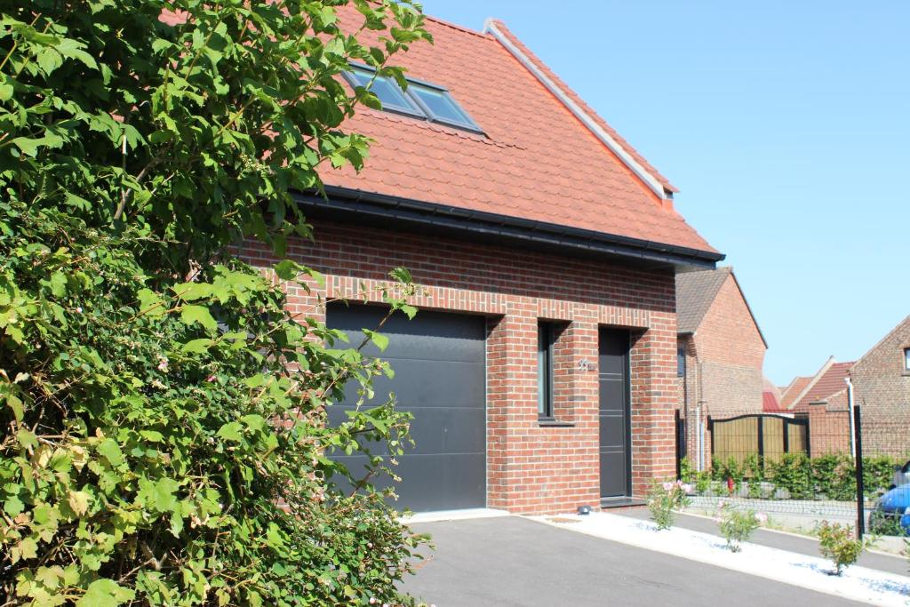 a garage door on a brick house at Le 99 bis - Escapade Nature - Vallée de la Sensée in Hamel