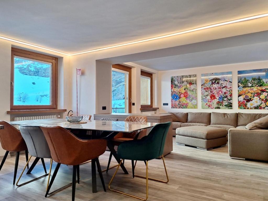 ein Wohnzimmer mit Tisch und Stühlen und einer Couch in der Unterkunft Cervinia Exclusive in Breuil-Cervinia