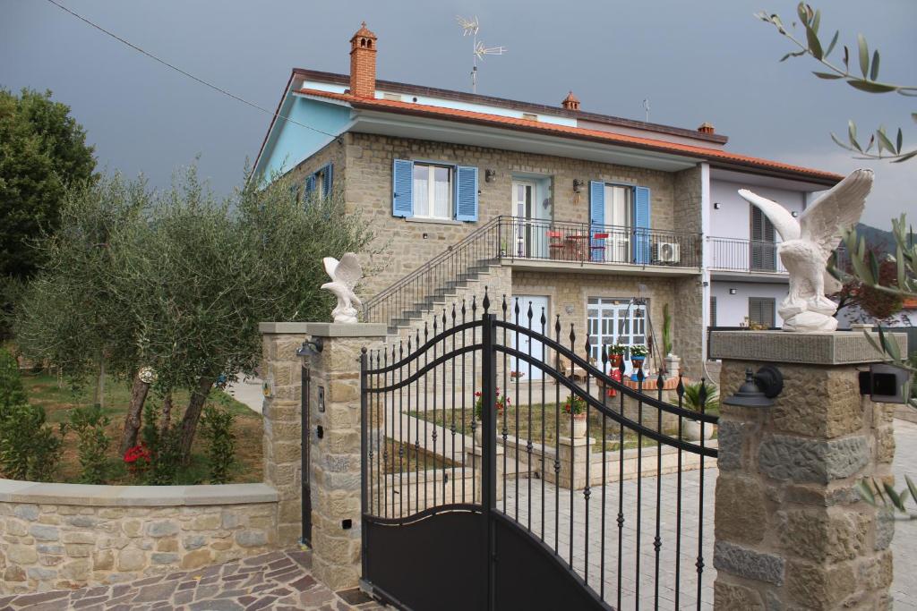 a house with a black gate and a stone fence at sole di campagna in Arezzo