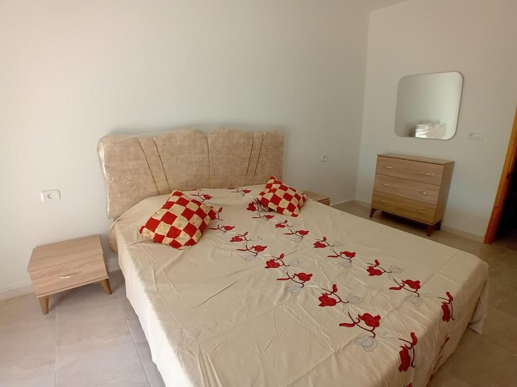 a bed with red roses on it in a bedroom at New and elegant apartment in the city center in Zarzis