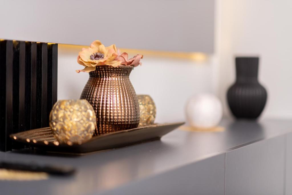 a vase with flowers in it sitting on a table at MM Stays G206 at Habitat Kappa - Sarona City in Gaborone
