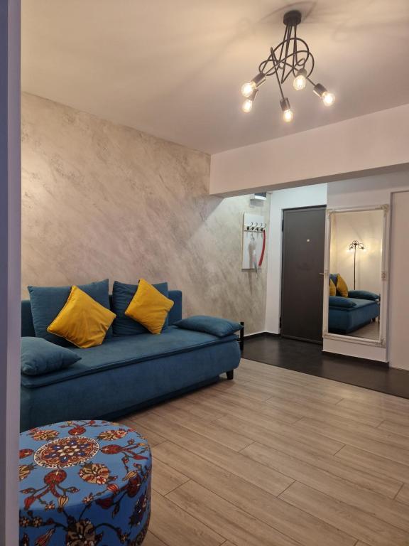 a living room with a blue couch and yellow pillows at Central Mangalia in Mangalia