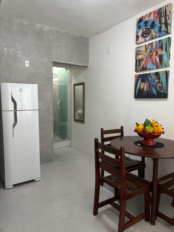 a kitchen with a table and a white refrigerator at Casas do Matteo - 2ª Praia in Morro de São Paulo